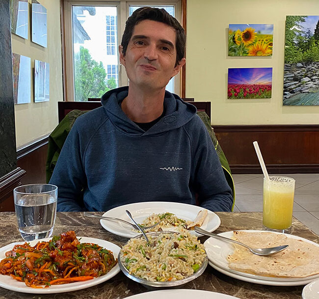 Alvaro en un restaurante en Munnar con naan, arroz y pollo en salsa roja picante.
